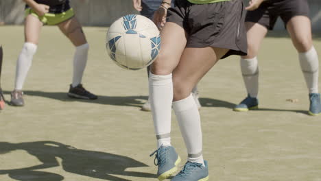 Medium-Shot-Of-An-Unrecognizable-Female-Football-Players'-Legs-Kicking-Soccer-Ball-At-The-Stadium