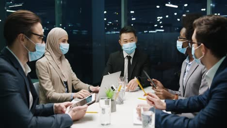 Multiethnische-Geschäftsleute-Gruppieren-Sich-In-Medizinischen-Masken-In-Einem-Teammeeting-In-Einem-Modernen-Büro-Und-Diskutieren-über-Ein-Projekt-2