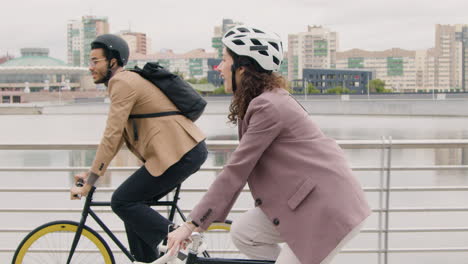 American-Man-And-Woman-Riding-Bikes-And-Talking-To-Each-Other-While-Going-To-Work