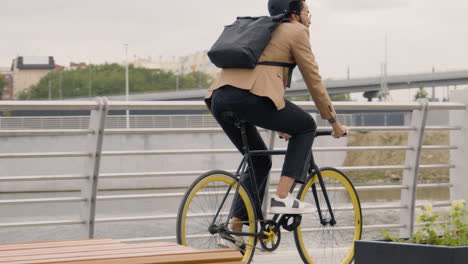 Young-American-Man-In-Formal-Clothes-With-Helmet-And-Backpack-Going-To-Work-On-Bicyle