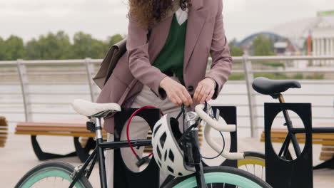 Close-Up-Of-An-Unrecognizable-Woman-In-Formal-Clothes-Parking-Her-Bike-On-The-City-Bridge-While-Going-To-Work