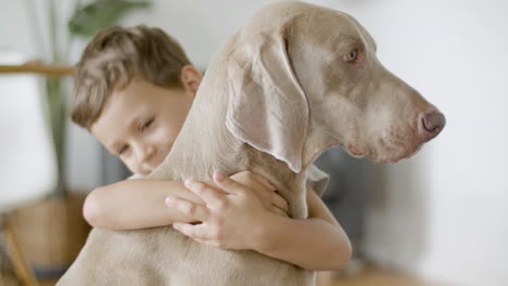 Niño-Alegre-Abrazando-A-Su-Adorable-Perro-En-Casa