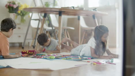 Niños-Tirados-En-El-Suelo-Y-Dibujando-Con-Lápices-De-Colores