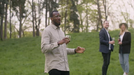 Middle-Aged-Man-Dancing-While-Holding-A-Wine-Glass-In-The-Park