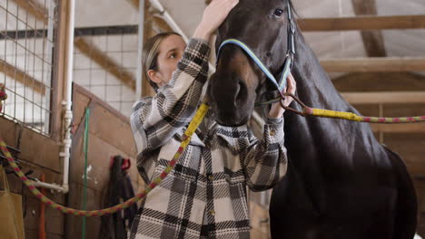 Black-Horse-Is-Loved-And-Caressing-By-Her-Brunette-Jockey-Inside-The-Stable