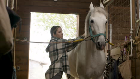 Teenager-In-Checkered-Coat-Petting-White-Horse-At-The-Stable
