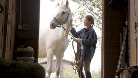Young-Woman-Caring-And-Playing-With-White-Horse-Outside-The-Stable