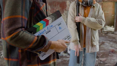 The-Camera-Focus-On-To-The-Hands-Of-An-Production-Worker-As-He-Holds-A-Clapperboard