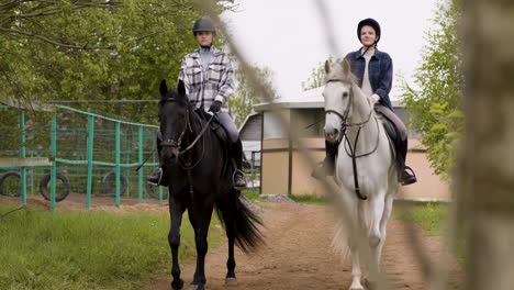 Two-Teenagers-Smiling-And-Riding-Horses-On-Cloudy-Day