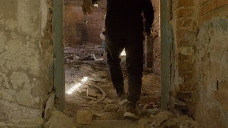 Rear-View-Of-A-Man-In-Black-Balaclava-And-Holding-An-Ax-Persecuting-A-Redheaded-Girl-In-A-Ruined-Building