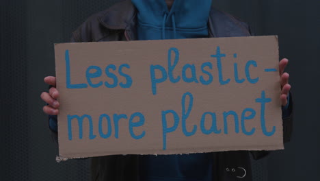 Close-up-view-of-a-cardboard-placard-with-the-phase-less-plastic
