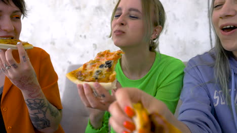 Closeup-view-of-friends-having-a-good-time-and-eating-pizza