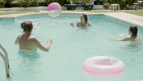 Caucasian-family-playing-ball-in-swimming-pool-on-a-summer-day
