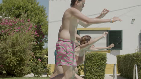 Cheerful-parents-and-kids-running-into-swimming-pools-together