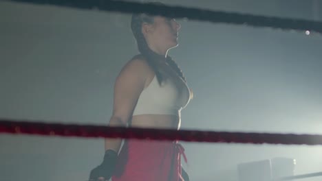 Young-Caucasian-sportswoman-with-braided-pigtails-jumping-rope-in-boxing-ring