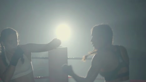 Junge-Boxerinnen-Kämpfen-Beim-Gemeinsamen-Training-In-Der-Boxhalle-Im-Dunkeln
