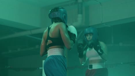 Zwei-Boxerinnen-In-Helmen-Und-Boxhandschuhen-Trainieren-Im-Ring