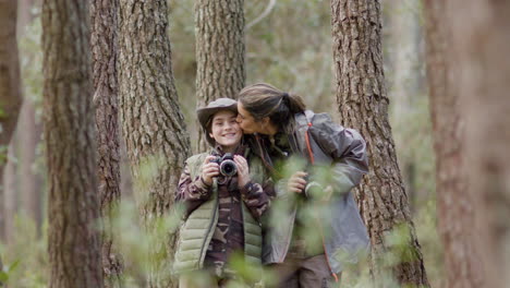 Mother-and-son-posing-with-photos-cameras-and-showing-affection-while-exploring-forest