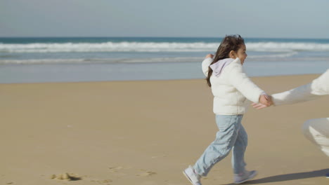 Adorable-little-Japanese-girl-running-to-her-dad-and-falling-into-his-arms-on-the-beach