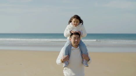 Happy-dad-giving-his-cute-little-daughter-ride-on-his-shoulders