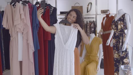 Mujer-Latina-Positiva-Haciendo-Selfie-Con-Vestido-Blanco-En-Una-Tienda