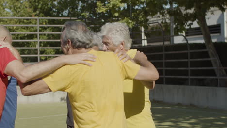 Felices-Jugadores-De-Fútbol-Senior-Abrazándose-Y-Saltando-En-Círculo-Juntos-Para-Celebrar-La-Victoria