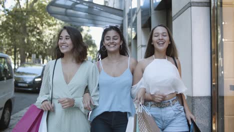 Tres-Mujeres-Felices-Caminando-Juntas-Y-Riendo-Con-Bolsas-De-Compras