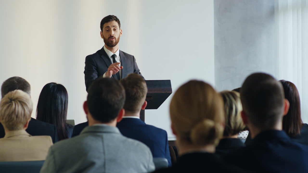 Free stock video - Caucasian businessman speaker on a podium wearing ...