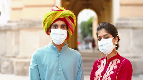 Close-up-of-Indian-couple-wearing-surgical-masks-outdoors