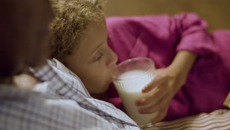 Closeup-of-girl-listening-to-goodnight-stories-and-sipping-milk