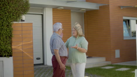Senior-couple-standing-outdoor-and-discussing-buying-a-new-house