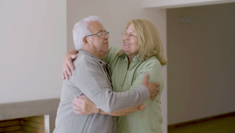 Cheerful-senior-couple-hugging-after-buying-new-house