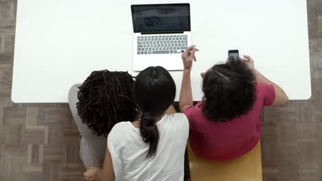 Vista-Superior-De-Las-Mujeres-Que-Trabajan-Con-Una-Computadora-Portátil-Mientras-Están-Sentadas-En-La-Mesa