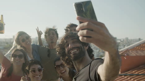 Hombre-Barbudo-Feliz-Tomando-Una-Foto-Selfie-Con-Amigos-Durante-Una-Fiesta-En-La-Azotea