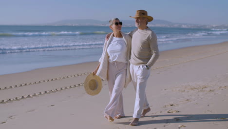 Happy-senior-Caucasian-couple-walking-on-the-beach-on-a-sunny-day