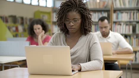 Vista-Frontal-De-Una-Mujer-Afroamericana-Seria-Usando-Una-Laptop