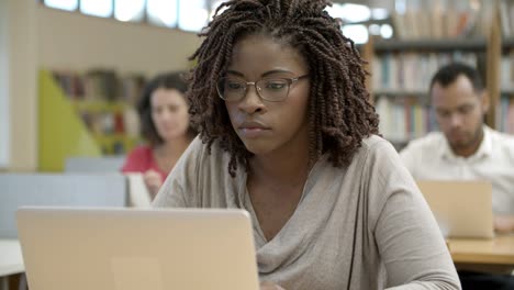 Primer-Plano-De-Una-Mujer-Afroamericana-Seria-Usando-Una-Computadora-Portátil