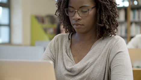 Primer-Plano-De-Una-Mujer-Afroamericana-Seria-Usando-Una-Computadora-Portátil