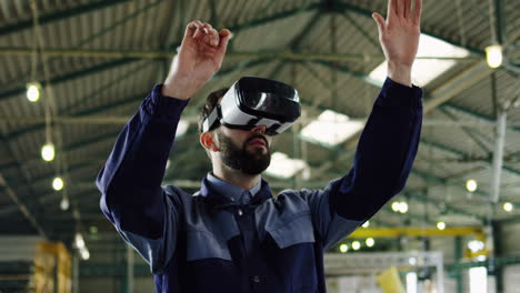 Male-factory-worker-wearing-VR-headset-in-a-big-factory