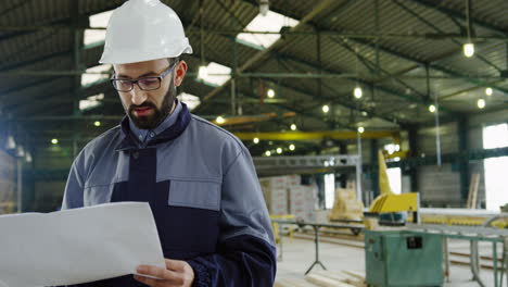 Caucasian-engineer-wearing-helmet-and-glasses-in-a-big-factory