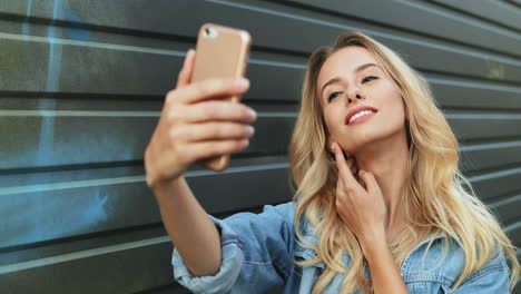 Junge-Kaukasische-Blonde-Frau-In-Jeansjacke,-Die-Ein-Selfie-Auf-Dem-Smartphone-Auf-Der-Straße-Macht