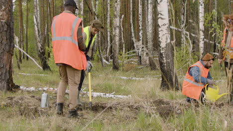 Grupo-De-Activistas-Ecologistas-Multiétnicos-Plantando-árboles-Y-Preparando-La-Tierra-En-El-Bosque