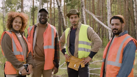 Multiethnic-group-of-ecologist-activists-posing-and-smiling-at-the-camera-in-the-forest