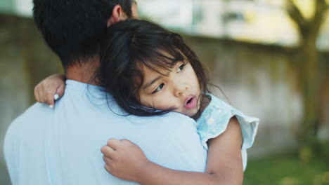 Smiling-cute-Asian-daughter-in-arms-of-her-father-outdoors