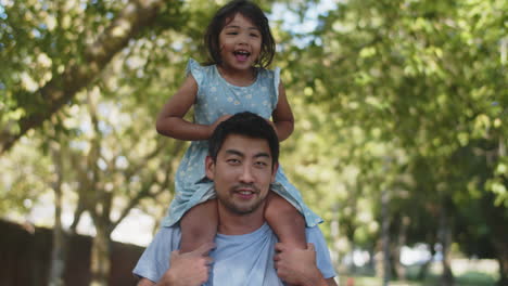 Young-Asian-man-giving-his-daughter-a-piggyback-ride-in-park
