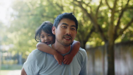 Glücklicher-Junger-Asiatischer-Mann,-Der-Seiner-Tochter-Eine-Rückfahrt-Gibt