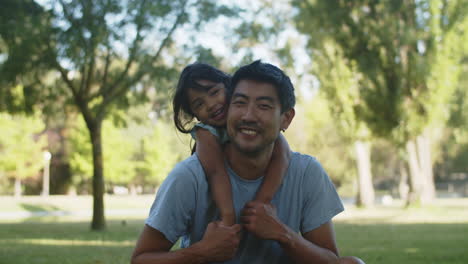 Porträt-Eines-Glücklichen-Asiatischen-Mannes,-Der-Mit-Seiner-Kleinen-Tochter-Sitzt