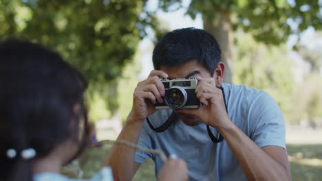 Joven-Padre-Asiático-Fotografiando-A-Su-Pequeña-Hija-En-El-Parque