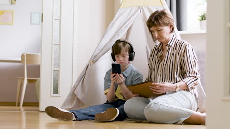 Mother-and-daughter-using-electronic-devices-at-home