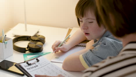 Girl-with-down-syndrome-doing-maths-with-her-mother-in-her-bedroom
